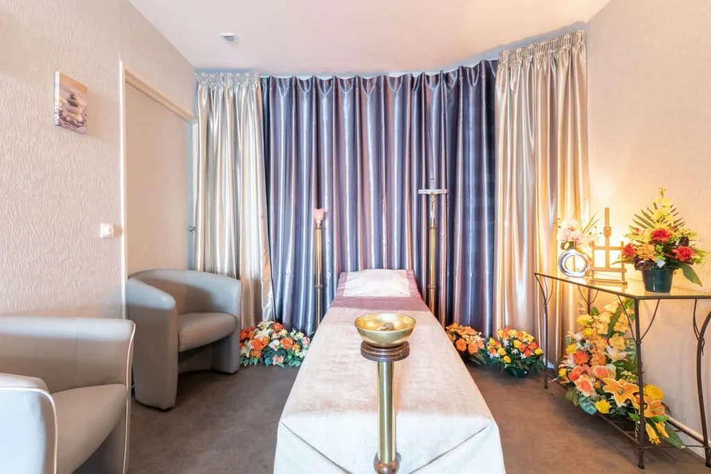 Chambre funéraire aménagée dans un funérarium avec salon de recueillement et fleurs