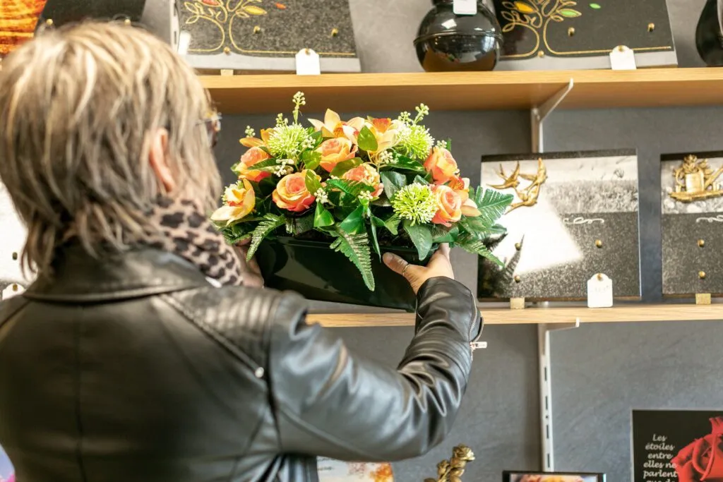 Cliente choisissant une composition de fleurs artificielles funéraires en boutique