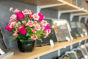 Pot de fleurs funéraires roses en détail sur étagère de magasin d'articles d'hommage